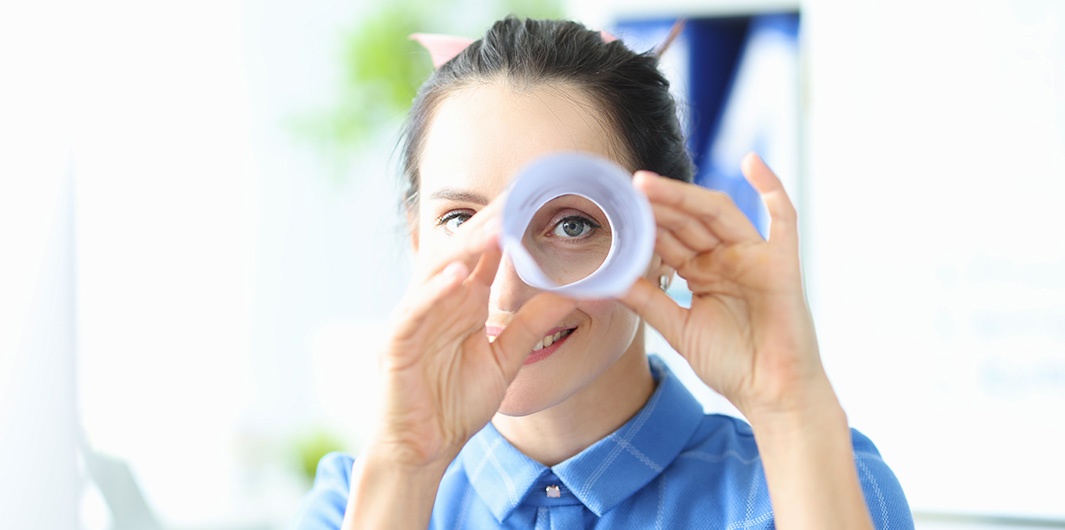 Frau, die ein Papier als Fernrohr nutzt