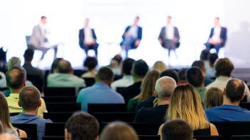 Podiumsdiskussion und Teilnehmende einer Veranstaltung