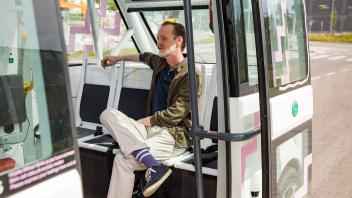 Mann sitzt in einem autonomen Bus