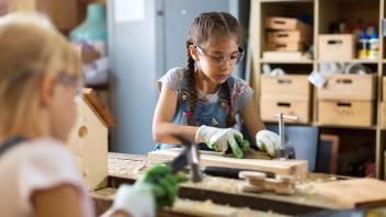 Zwei junge Mädchen bei der Holzbearbeitung in einer Werkstatt