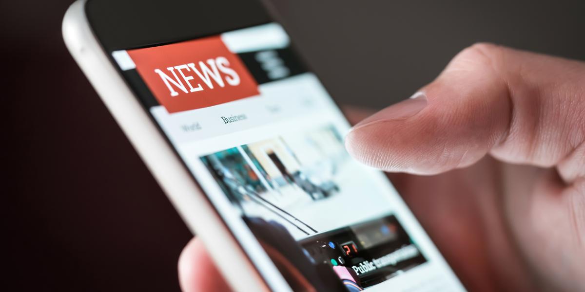 News - Mensch liest Neuigkeiten auf dem Mobiltelefon