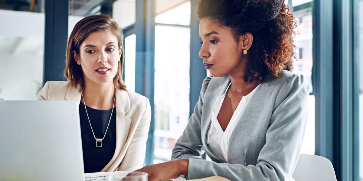 Zwei Frauen arbeiten gemeinsam in einem Büro und prüfen kritisch Unterlagen