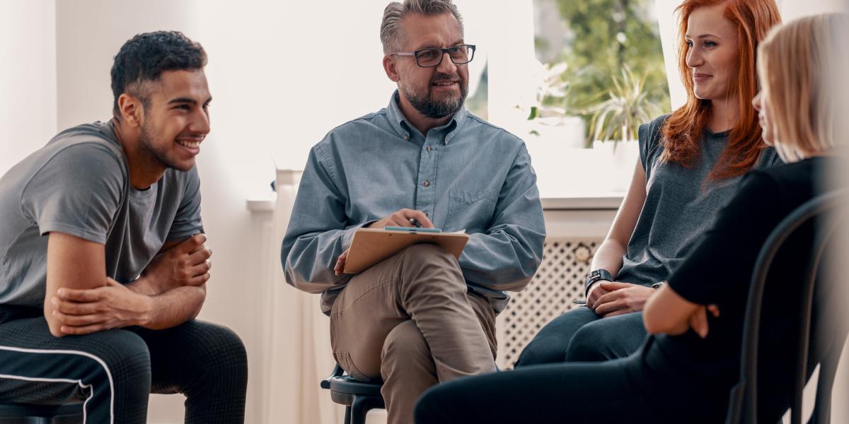 Eine Gruppe aus Menschen unterschiedlichen Alters und Herkunft diskutieren angeregt und fröhlich miteinander