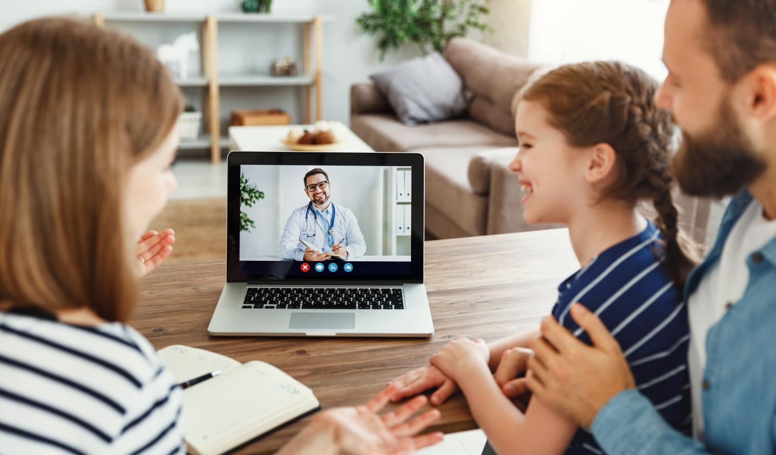 Vater mit seinen Kindern ist via Laptop mit einem Arzt online verbunden 