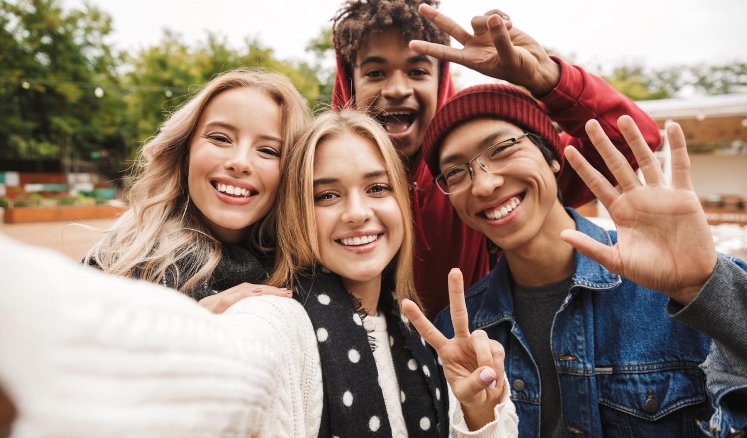 Eine vielfältige Gruppe junger Menschen macht ein gemeinsames Selfie