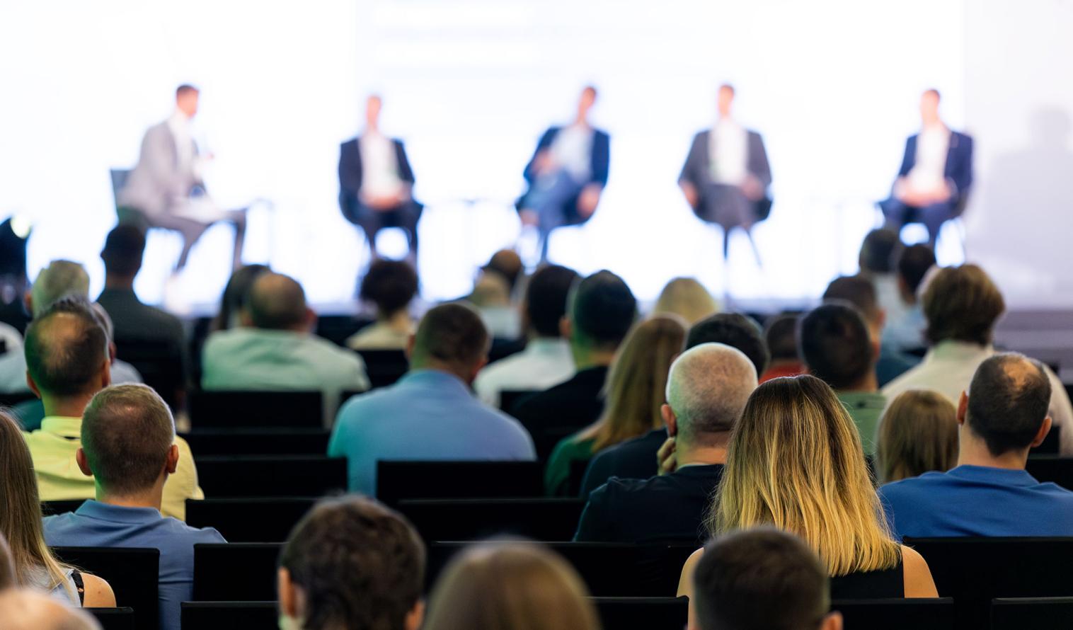 Podiumsdiskussion und Teilnehmende einer Veranstaltung
