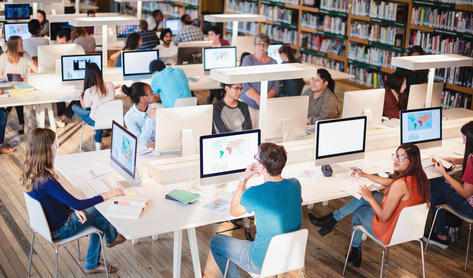 Studierende arbeiten an Bildschirmen in einer Bibliothek 