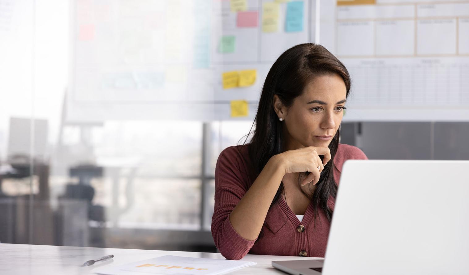 Frau arbeitet im Büro an einem Laptop