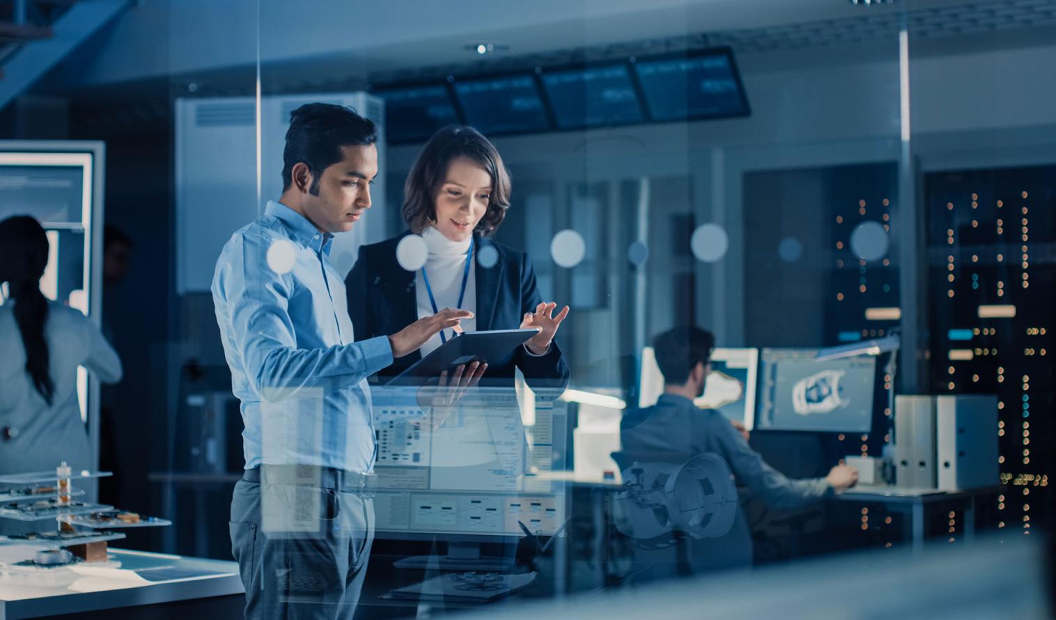 Ein Team aus Wirtschaftsingenieuren und Entwicklern arbeitet mithilfe von Computern an der Konstruktion eines Motors