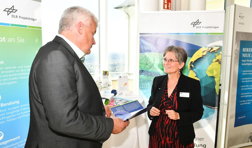 Eine Frau berät einen Mann am Infostand des DLR-PT.