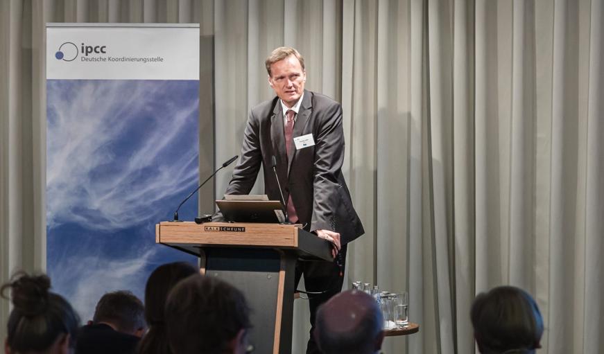 Karsten Sach steht auf der Bühne und spricht zum Publikum.